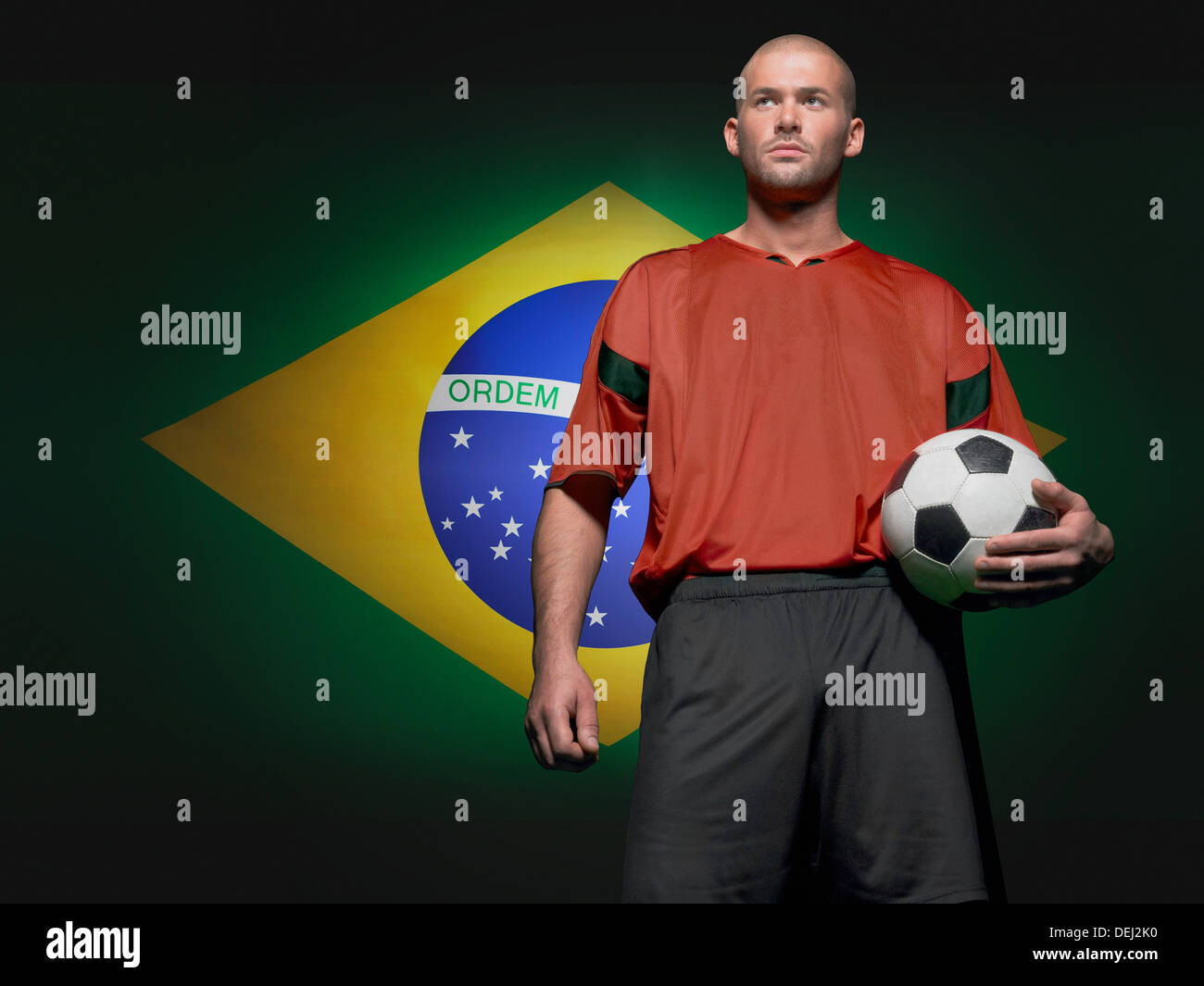Giocatore di calcio in piedi anteriore bandiera brasiliana Foto Stock