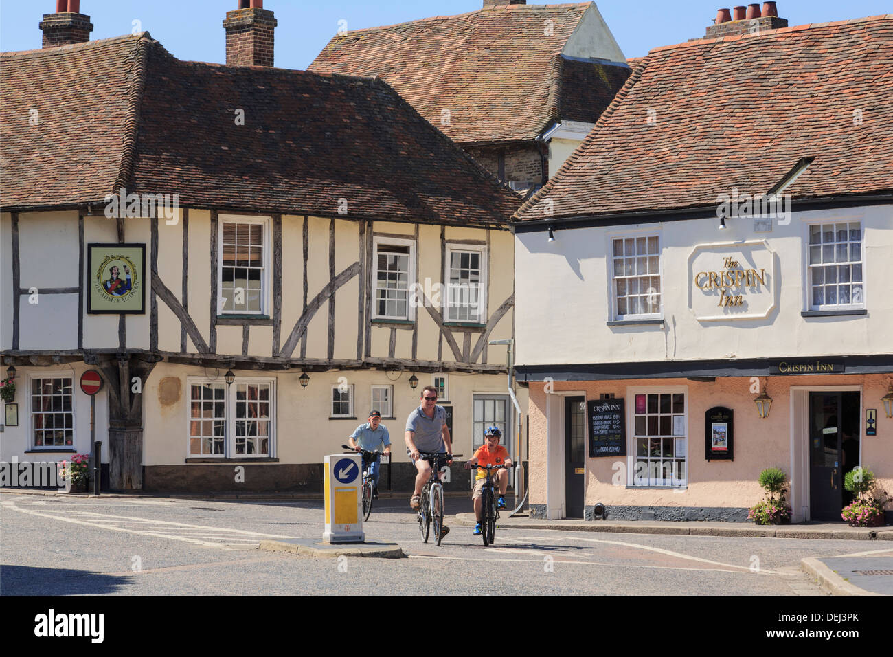 Persone ciclismo passato xv secolo Admiral Owen pub e il XVI secolo Crispin Inn nel centro storico di cinque città portuale di Sandwich Kent, Inghilterra, Regno Unito, Gran Bretagna Foto Stock