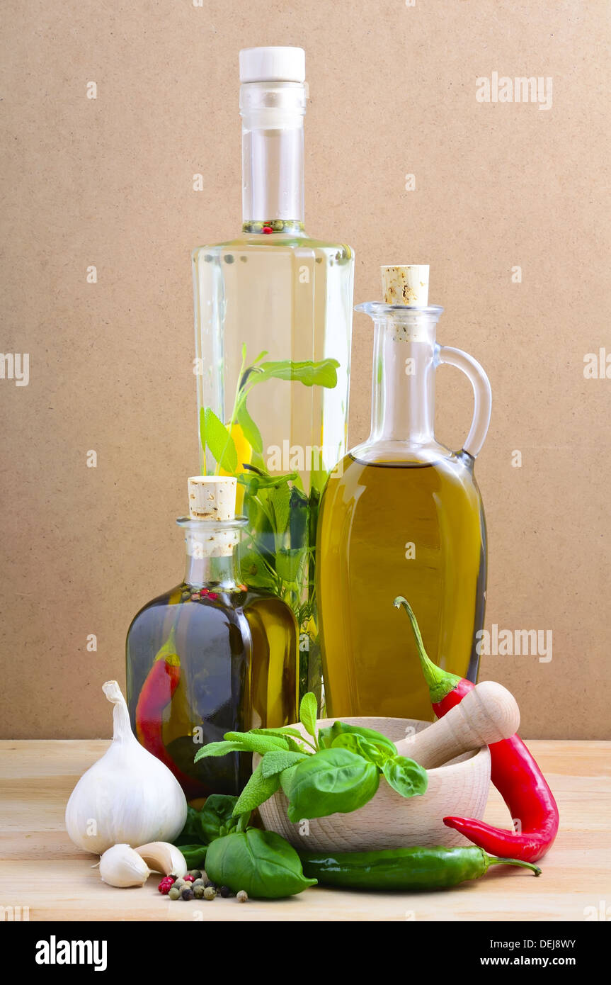 Gli ingredienti alimentari con olio a base di erbe, erbe aromatiche e spezie su uno sfondo di legno Foto Stock