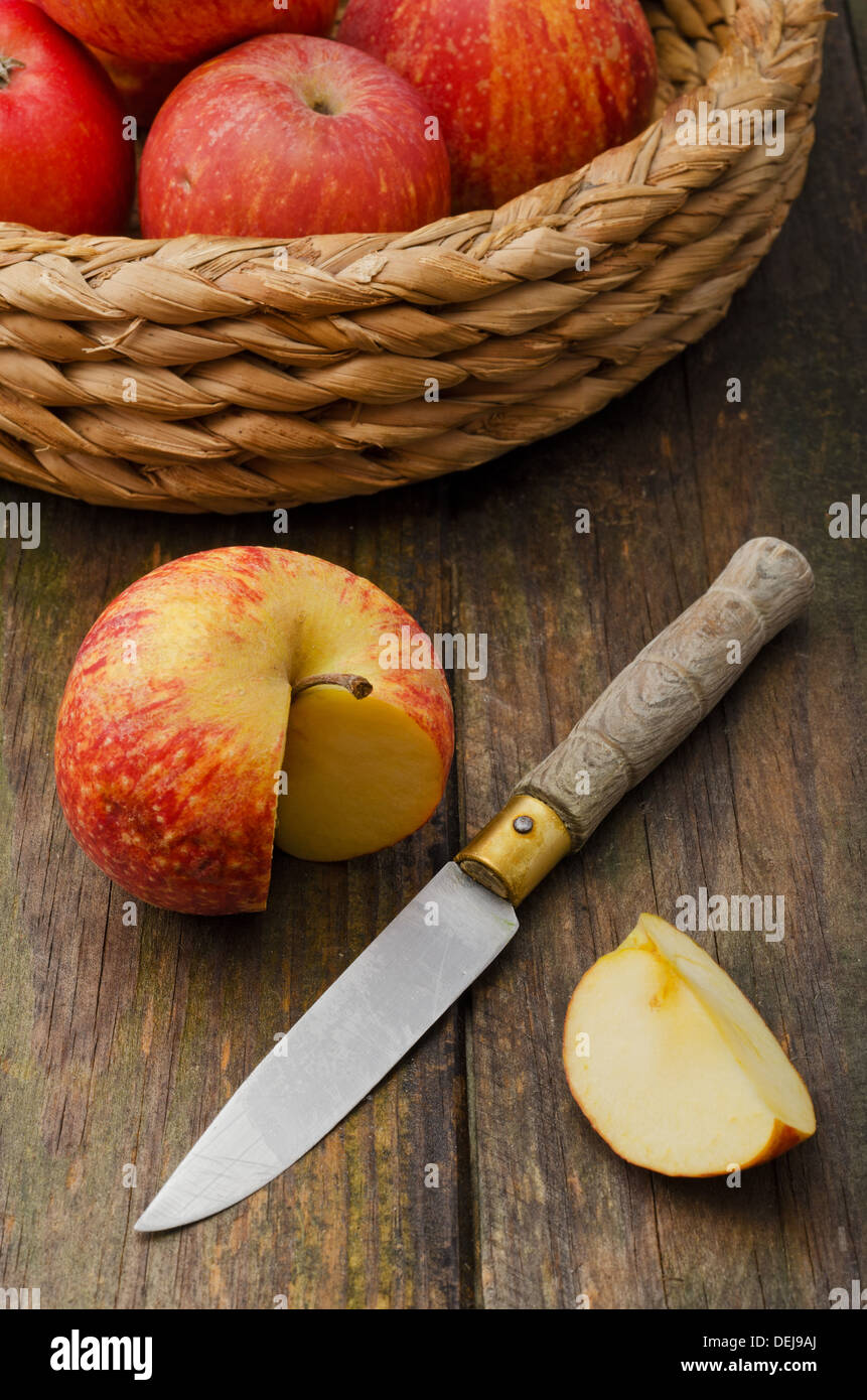 Cestino con mele e il coltello sul tavolo di legno Foto Stock