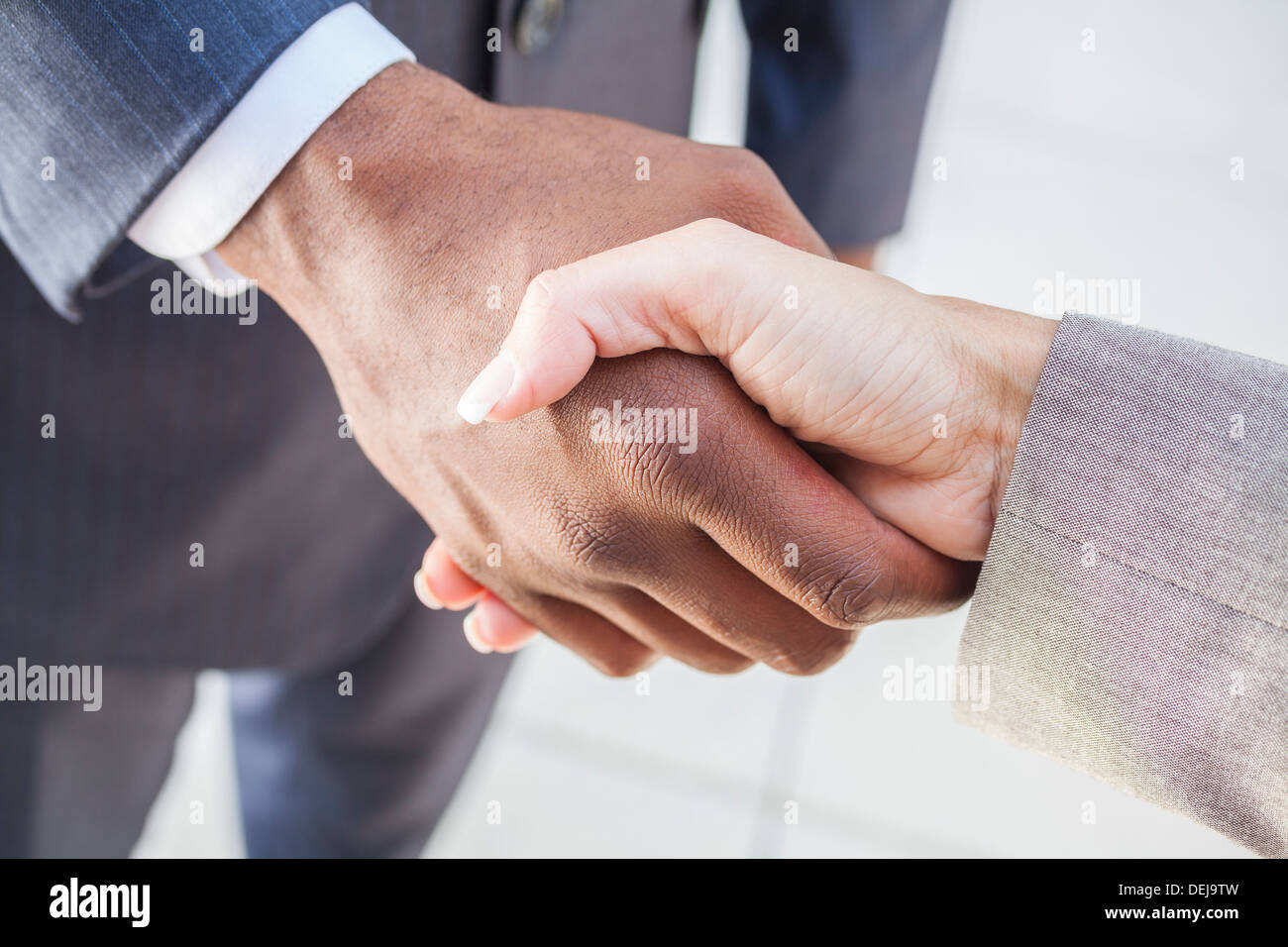 African American businessman o man mano tremante con un imprenditrice donna o femmina bianca collega facendo un affare di lavoro Foto Stock