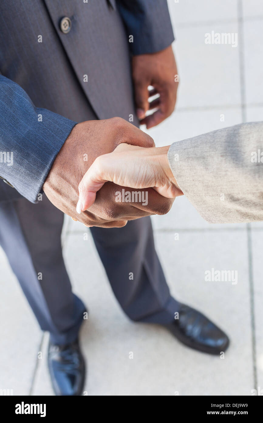 African American businessman o man mano tremante con un bianco o imprenditrice donna collega femmina facendo un affare di lavoro Foto Stock