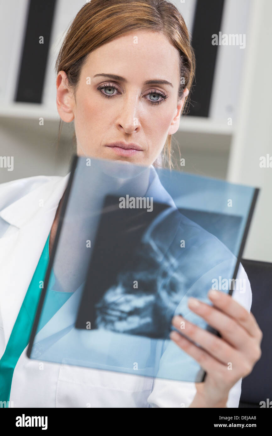 Una donna bionda medico cerchi a raggi x nel suo ufficio presso un ospedale Foto Stock