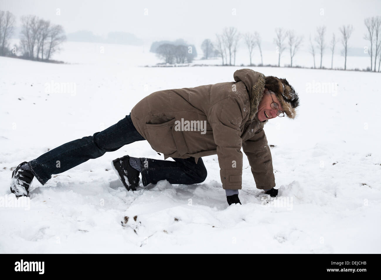 Active senior uomo esercita sulla neve in inverno. Foto Stock