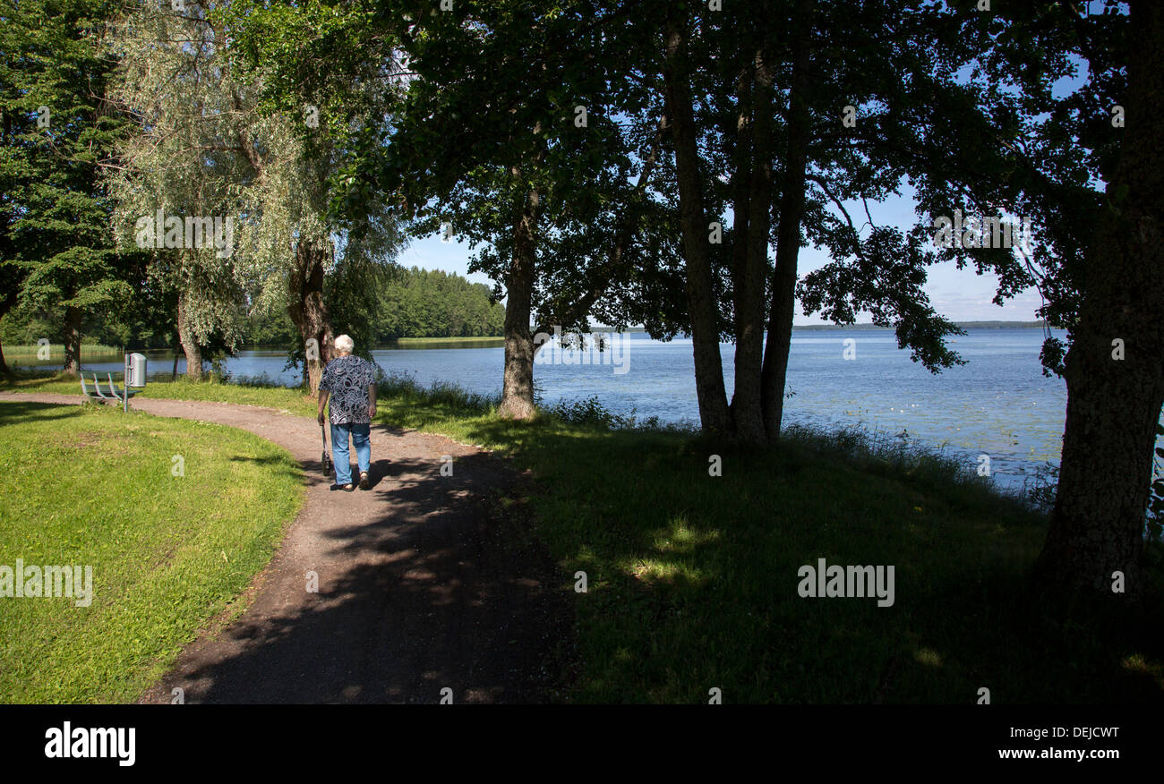 Donna anziana isolata che cammina in un parco pubblico a Pieksämäki, Finlandia Foto Stock