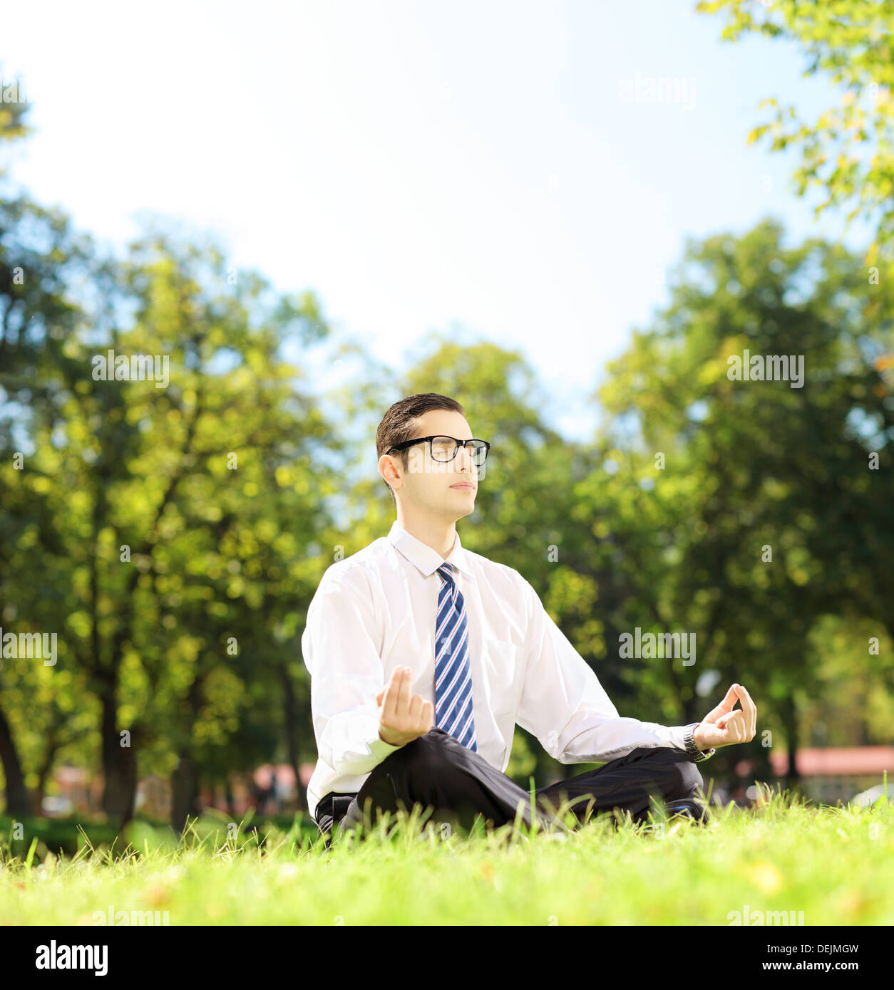 Giovani imprenditori meditando seduto su un prato in un parco Foto Stock