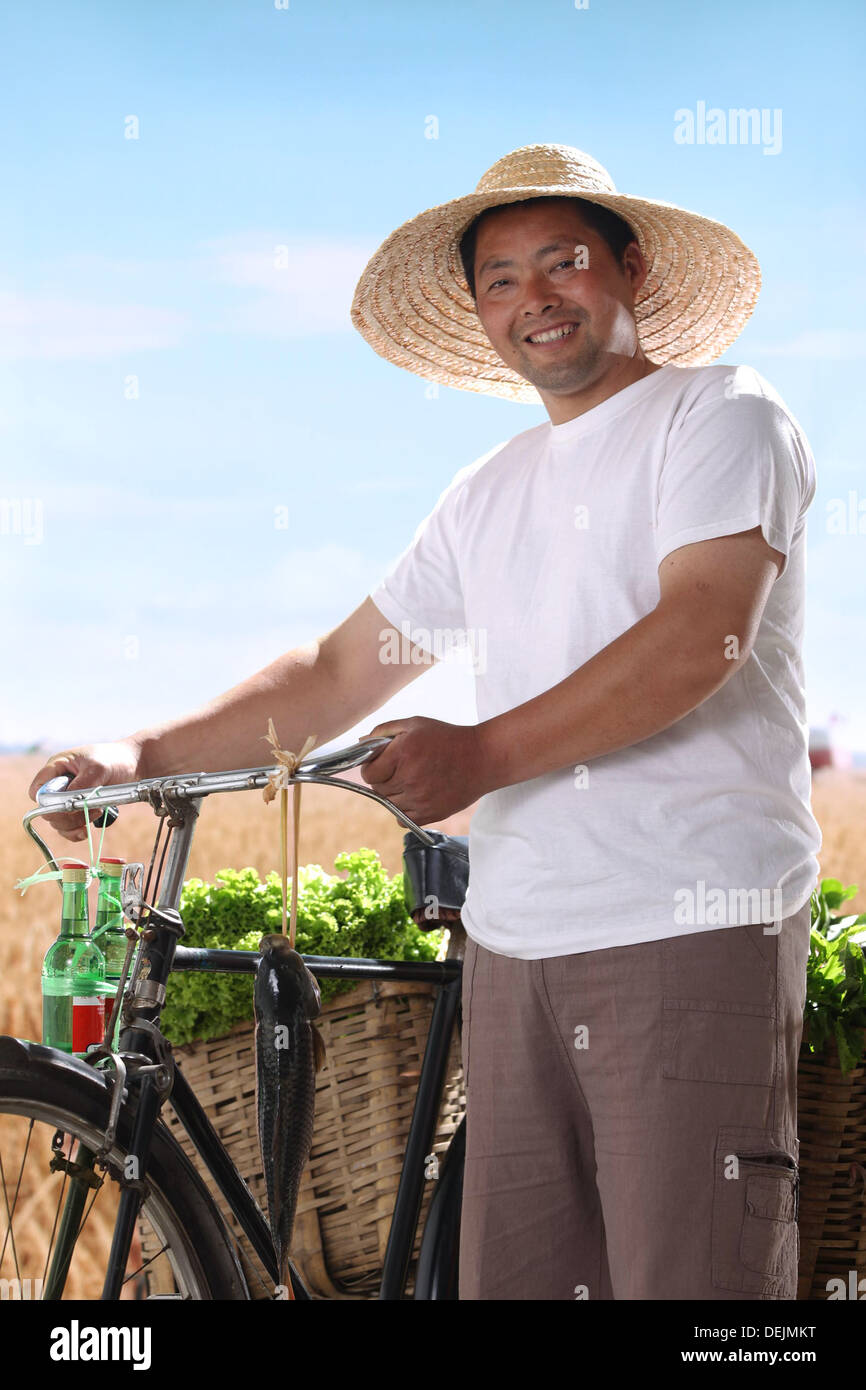 Agricoltore passeggiate in bici con verdura Foto Stock