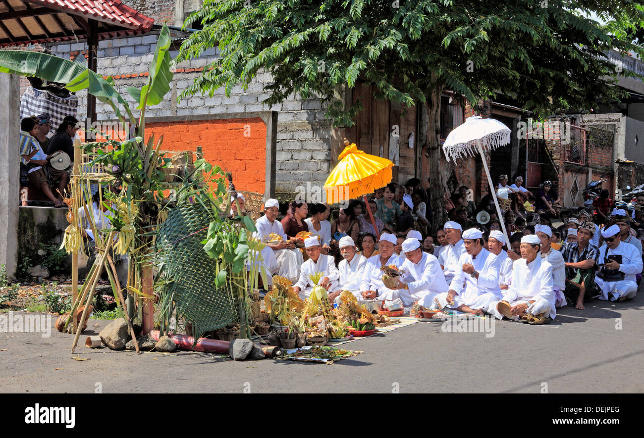 I sacerdoti seduti sulla strada a una cerimonia di strada in un piccolo villaggio nei pressi di Lovina, nord Bali, Indonesia Foto Stock