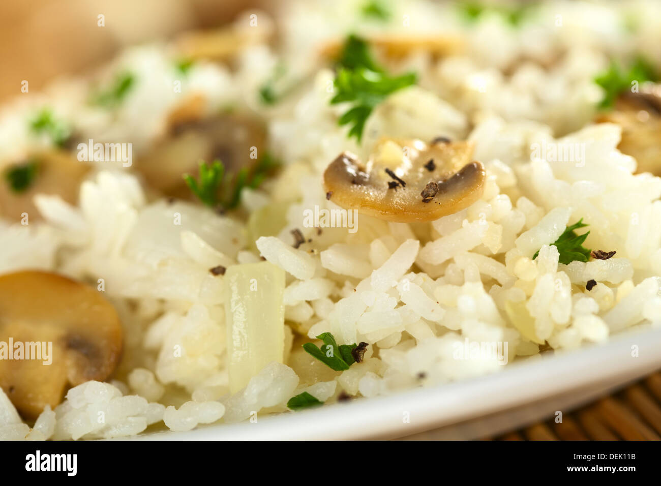 Risotto ai funghi con il prezzemolo (messa a fuoco selettiva, messa a fuoco sulla parte anteriore della fetta di fungo in medio) Foto Stock