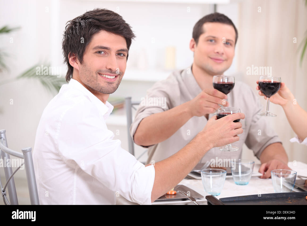 Giovani tintinnanti bicchieri di vino rosso Foto Stock