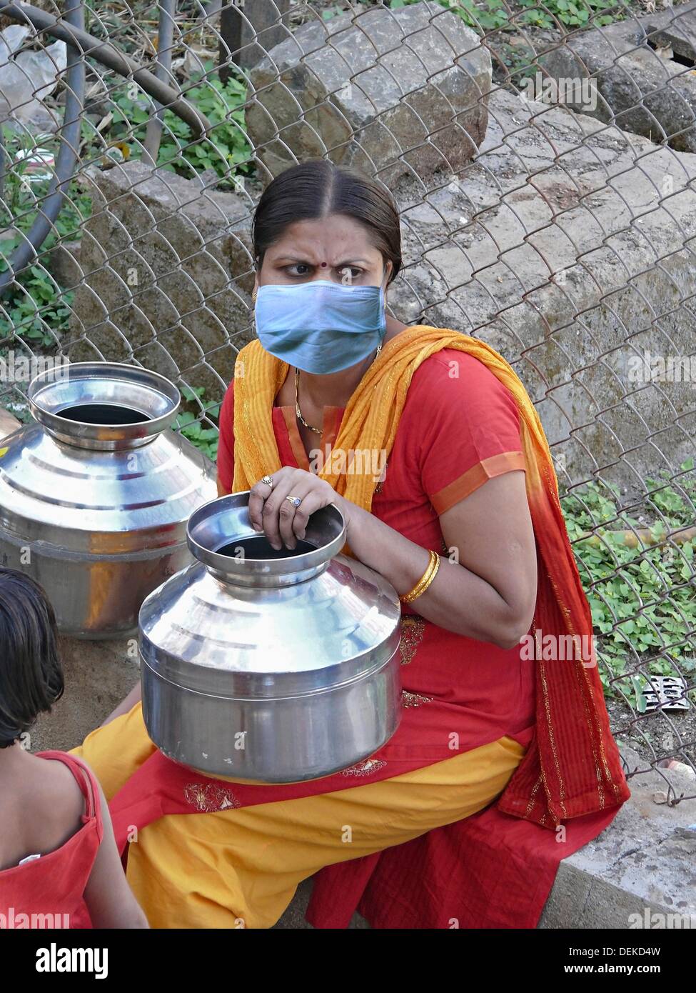Una donna ad acqua di comunità toccate con maschera, H1N1, India Foto Stock