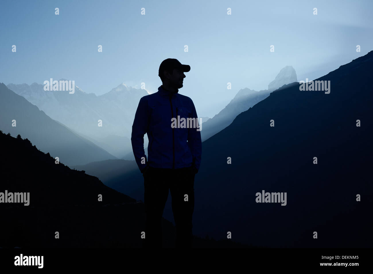 Uomo in piedi nella parte anteriore della gamma himalayana profilarsi all'alba - punto di vista al di sopra di Namche Bazaar - Everest dietro di lui a sinistra Foto Stock