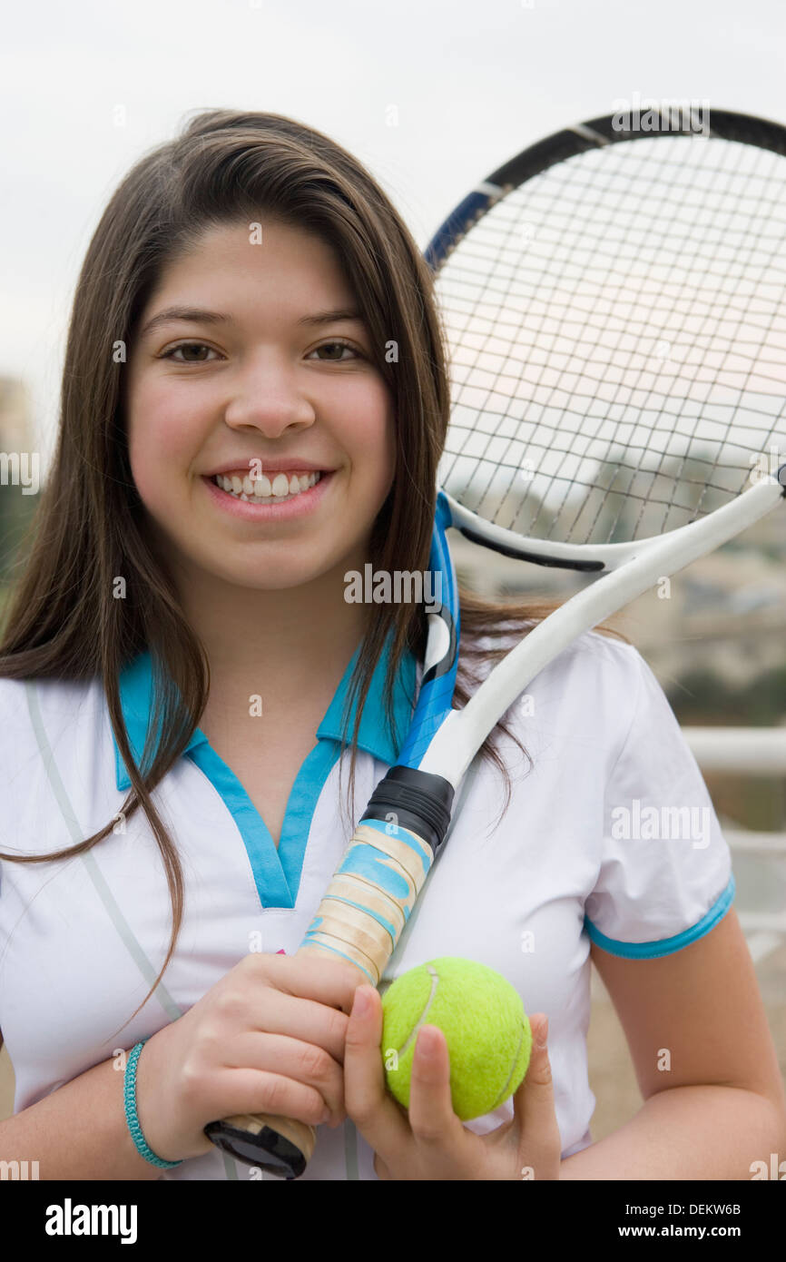 Ragazza ispanica giocando a tennis all'aperto Foto Stock