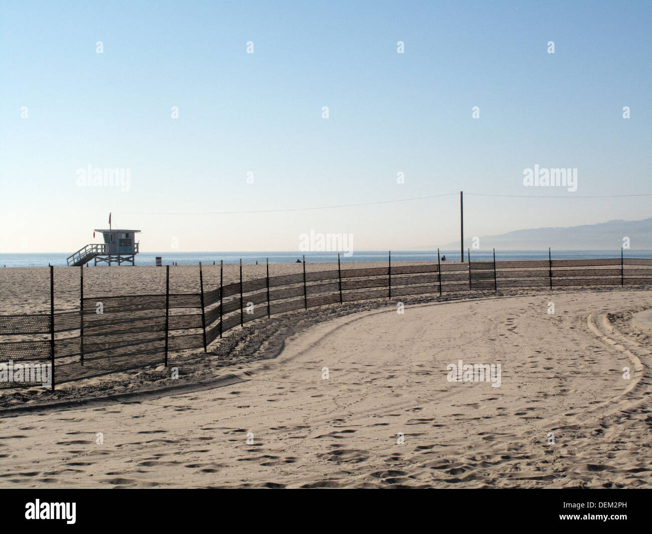 Spiaggia di sabbia con mesh barriera di recinzione, Venice Beach, California, Stati Uniti d'America Foto Stock