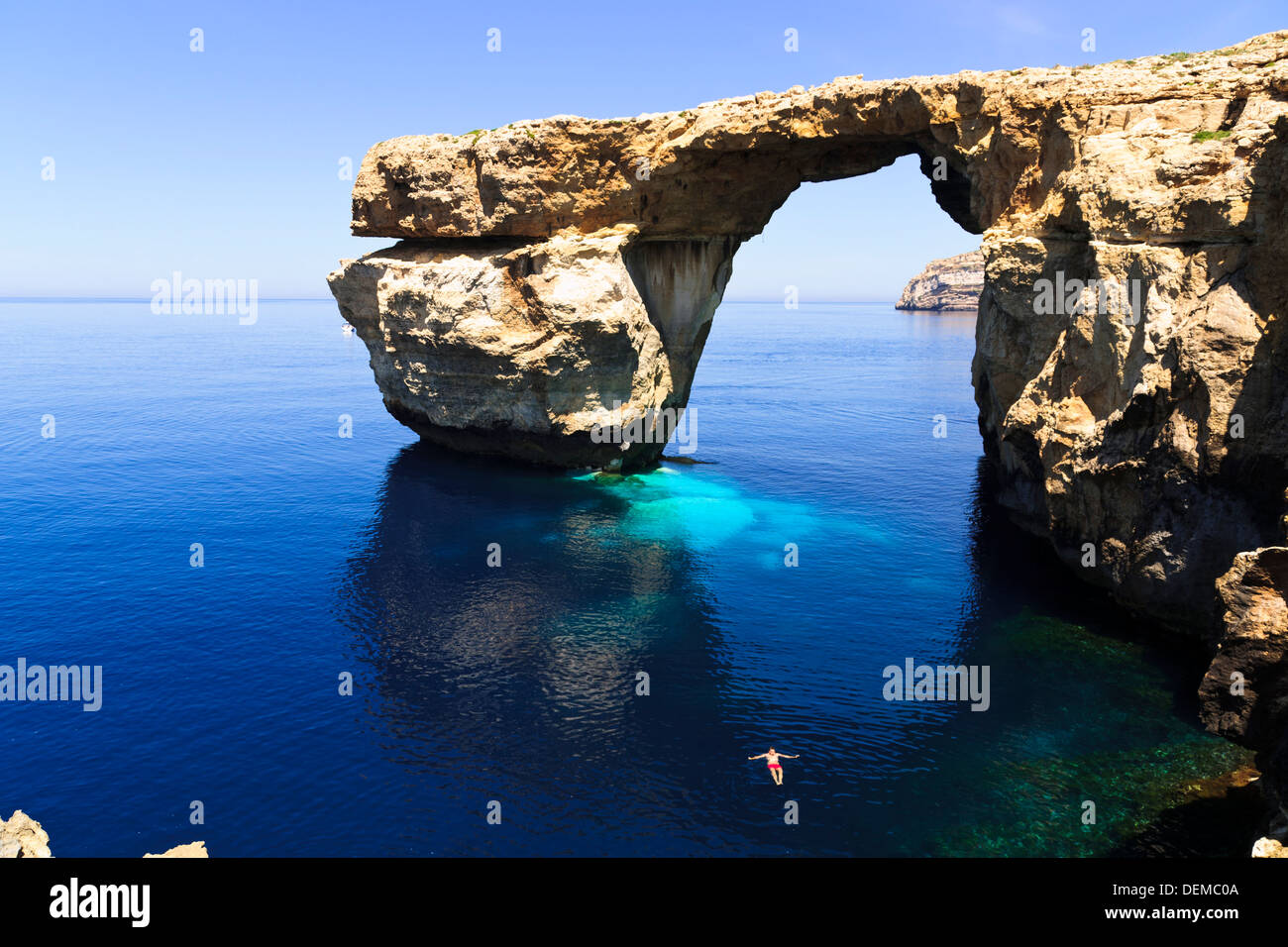 Uomo di nuoto di fronte Azure Window arco naturale a Dwerja, Gozo, Malta. Foto Stock