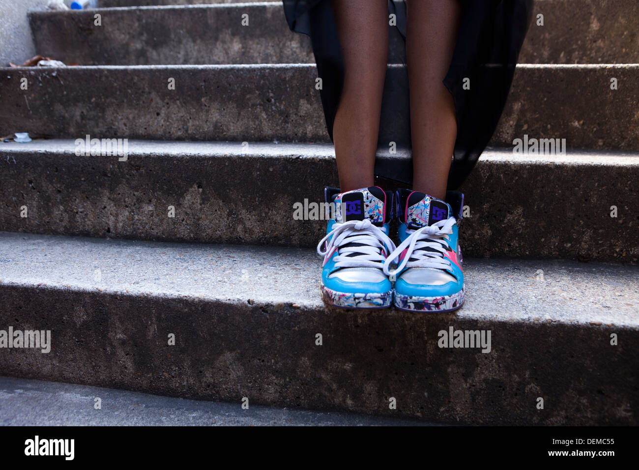 Primo piano di una ragazza che indossa la DG sneakers, stando in piedi sui gradini Foto Stock