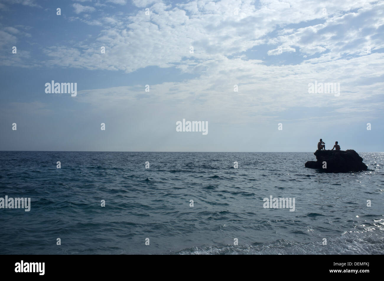 Due giovani uomini potrete rilassarvi su una roccia nel mare a Himara sulla Riviera albanese, a sud-ovest di Albania Foto Stock