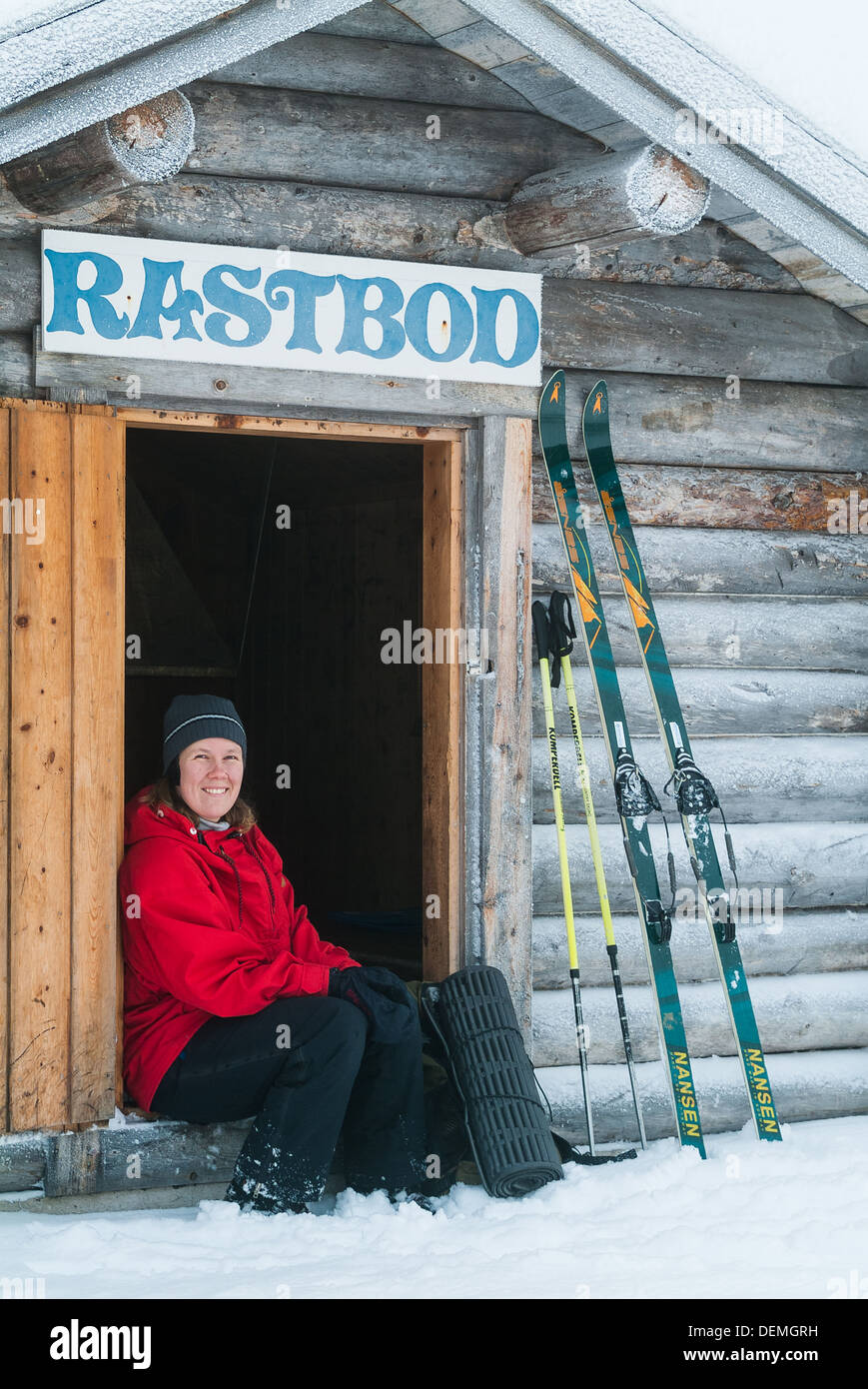 Donna seduta al di fuori del rifugio sciistico, Svezia. Foto Stock