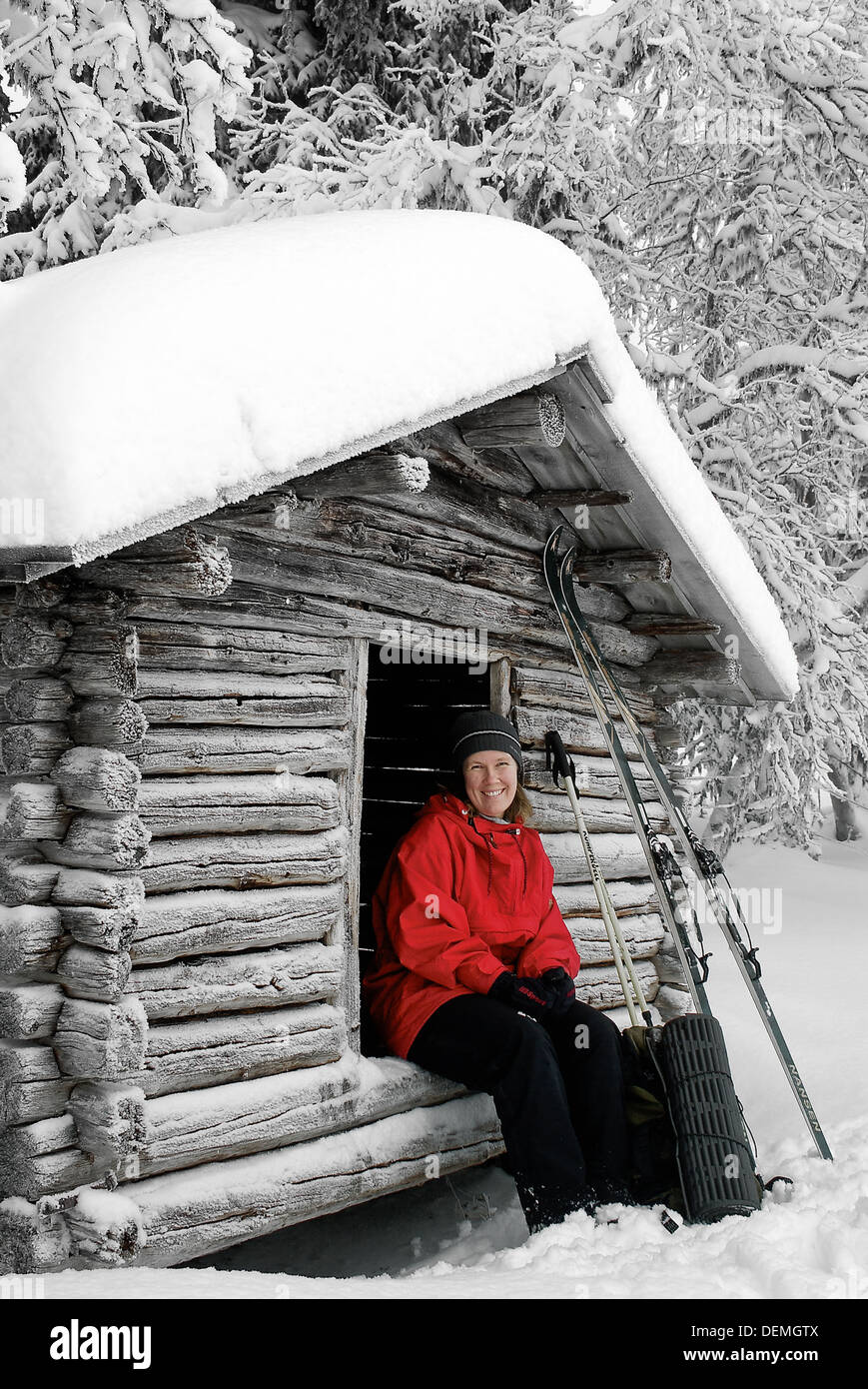 Donna seduta al di fuori del rifugio sciistico, Svezia. Foto Stock