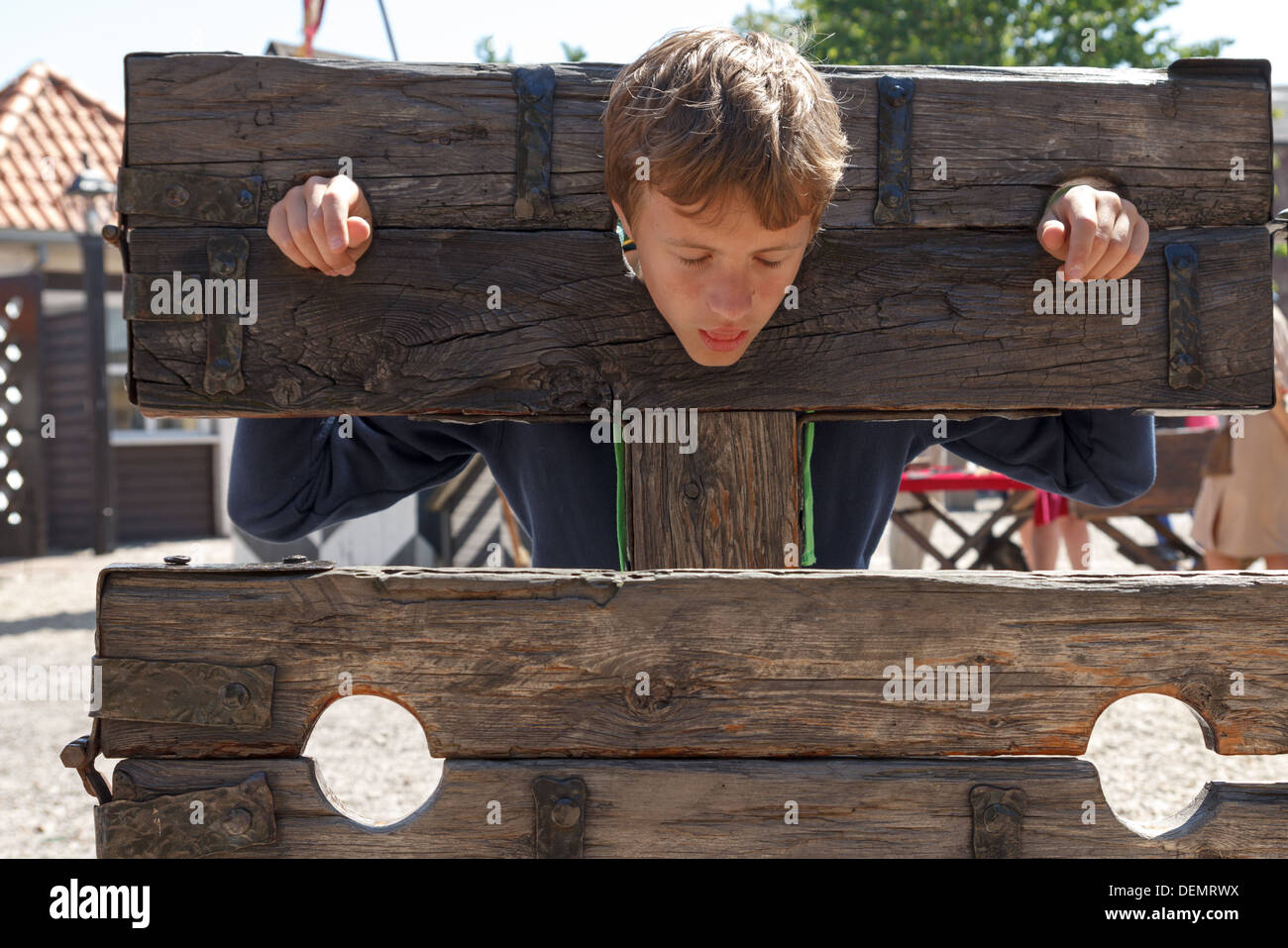 Un ragazzo intrappolato in una tortura medievale dispositivo Foto Stock
