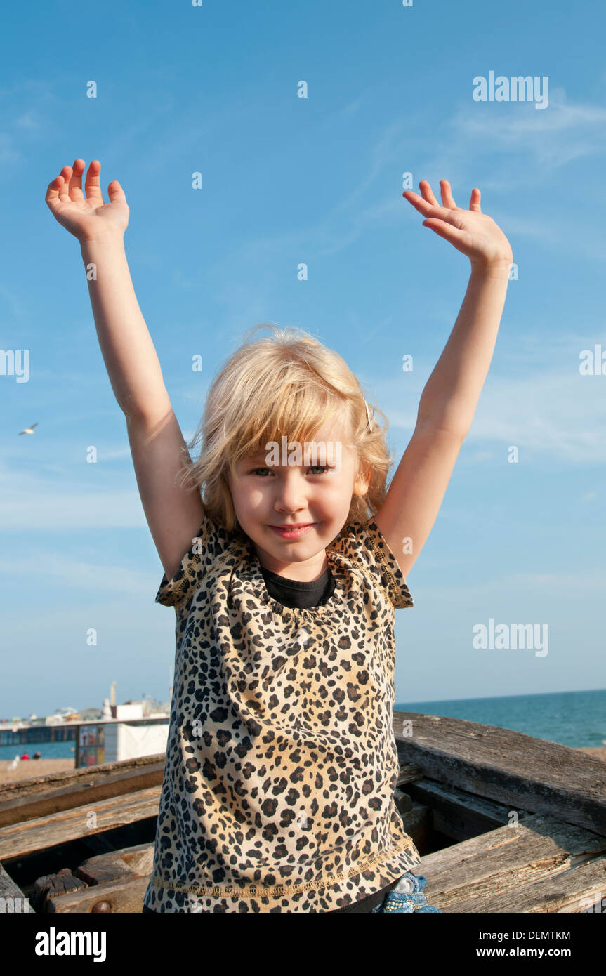 Giovane ragazza sorridente e agitando;Brighton East Sussex, Inghilterra, Europa, Regno Unito Foto Stock