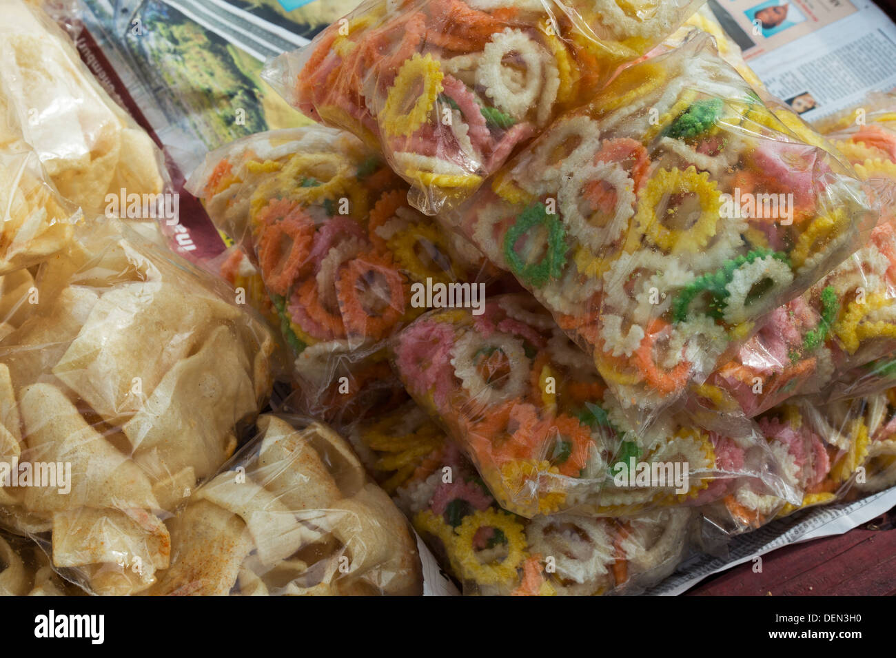 Fritte snack indiano in sacchetti di plastica per la vendita in un mercato indiano. India Foto Stock