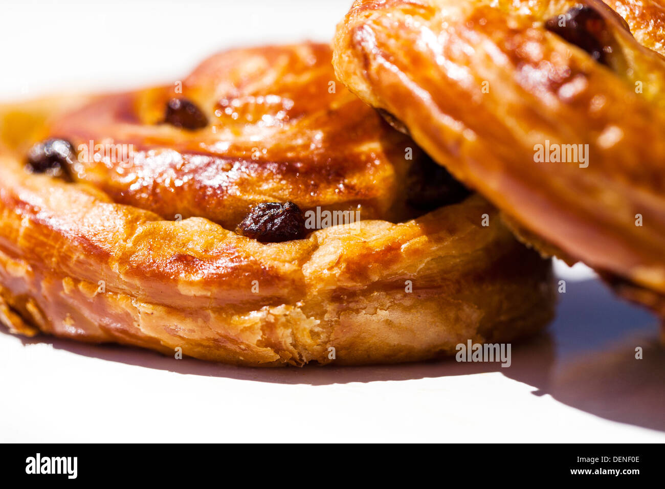 Due acquolina in bocca a scaglie sultana pasticceria danese è su una piastra, all'esterno, su un tavolo al sole Foto Stock