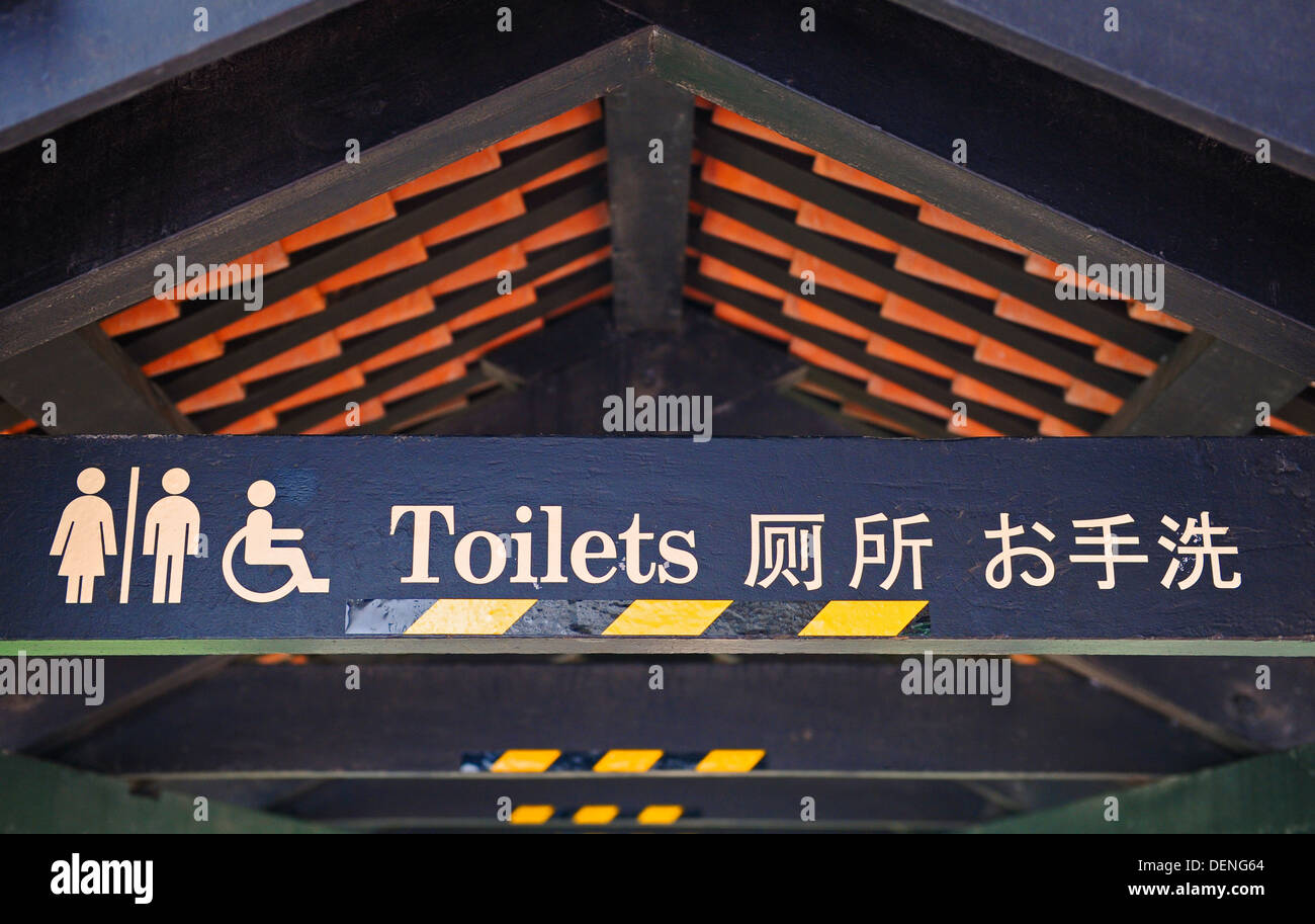 Segno per la toilette scritto in inglese e cinese presso i Giardini Botanici di Singapore. Foto Stock