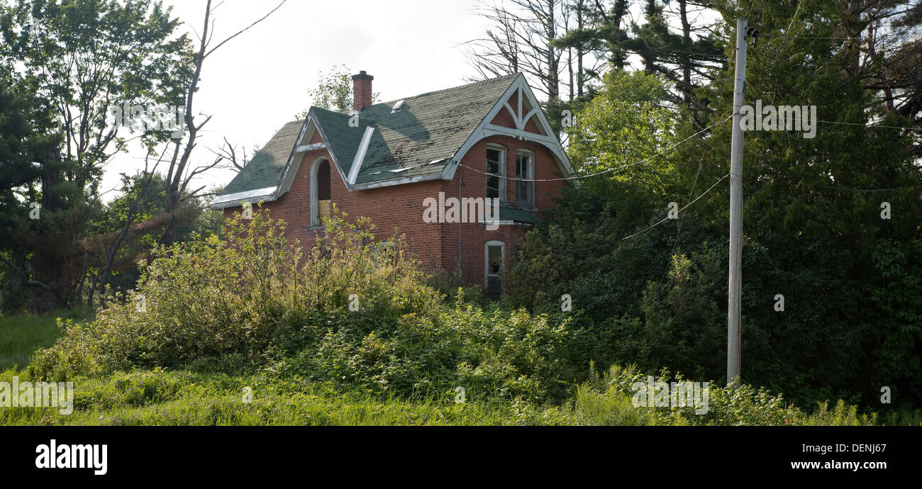 Una vecchia casa colonica lentamente vengono presi in consegna dalla natura in Muskoka, Ontario, Canada. Foto Stock