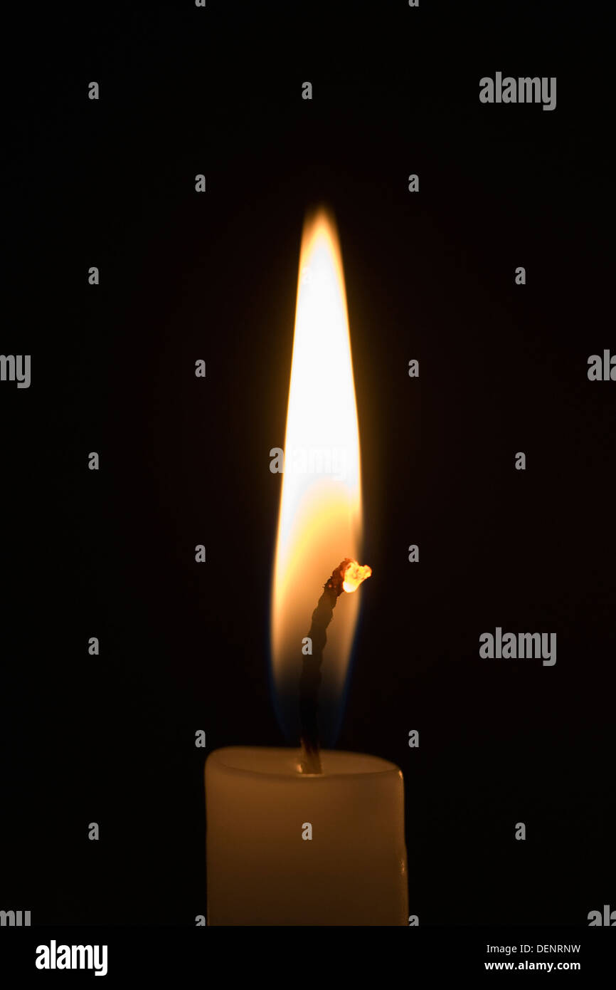 Una singola candela nelle tenebre. Foto Stock