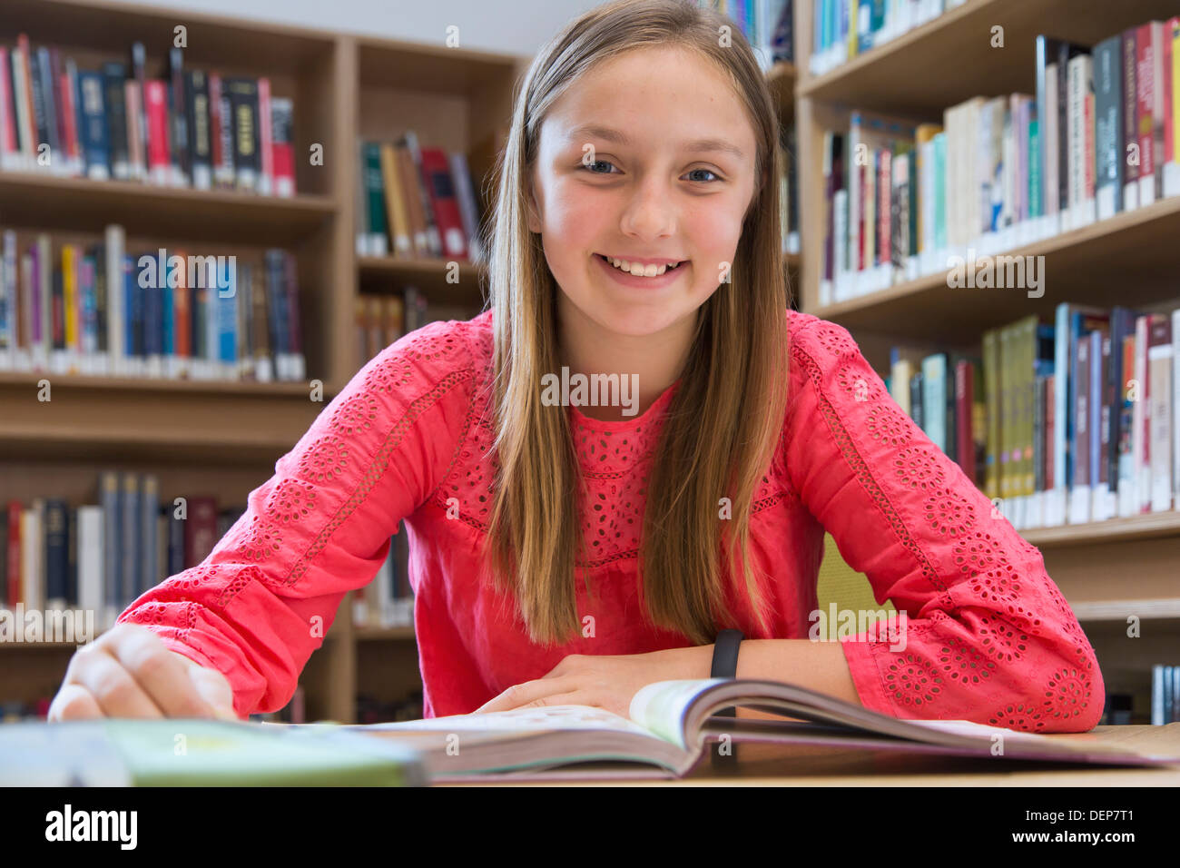 Studente caucasica sorridente in biblioteca Foto Stock