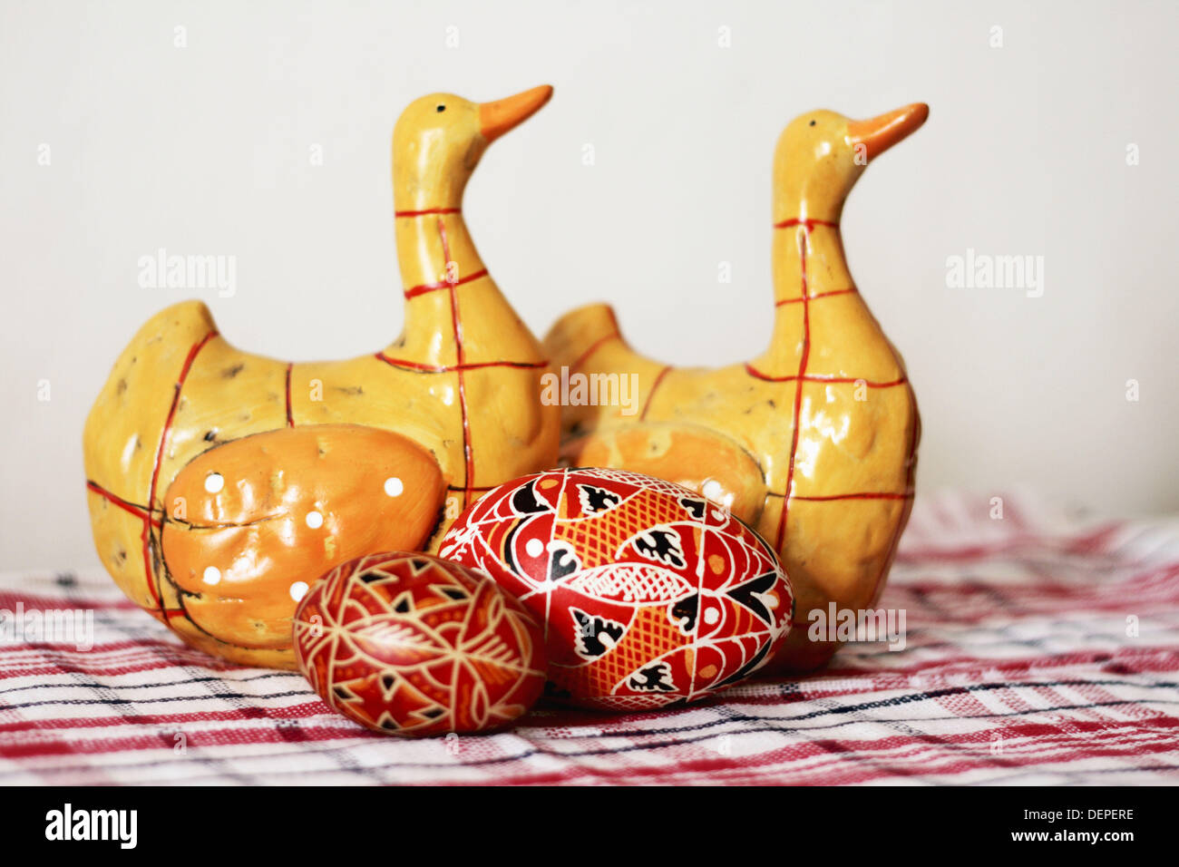 Due ceramica oche giallo quack circa due dipinti a mano rosso uova di  pasqua con disegni geometrici. i due giallo oche in ceramica Foto stock -  Alamy