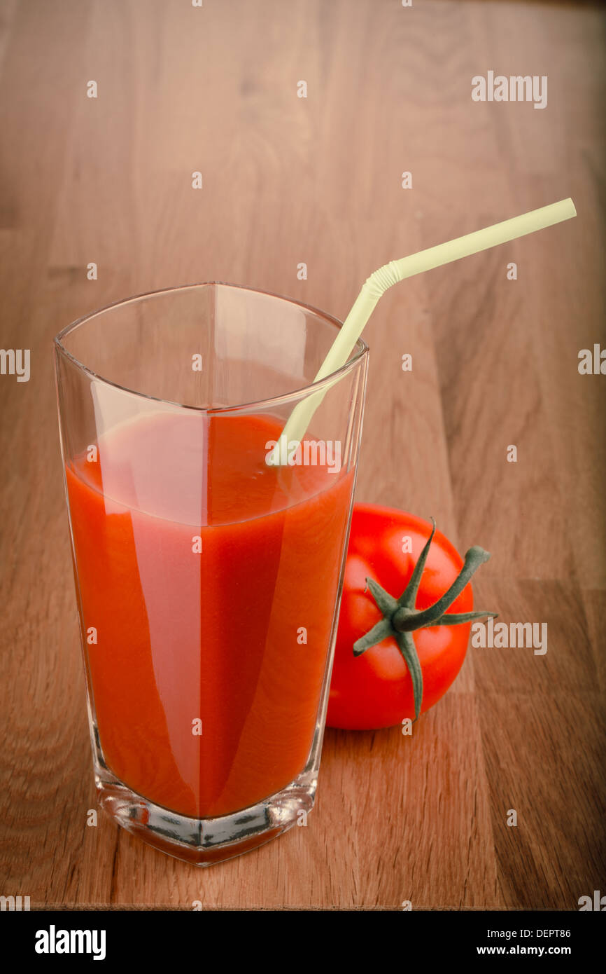 Il succo di pomodoro in un bicchiere con una cannuccia e pomodoro Foto Stock