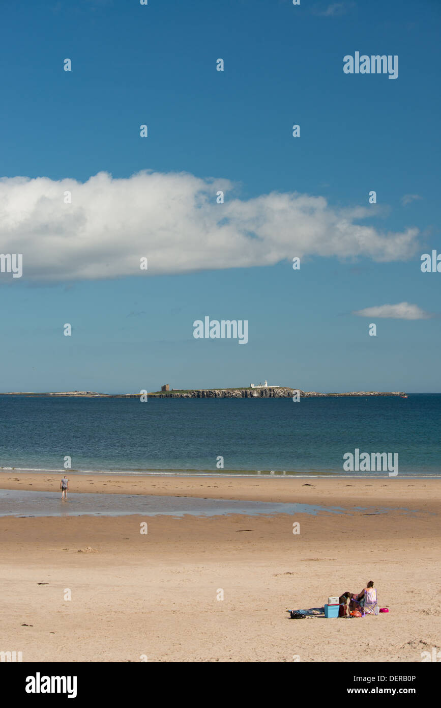 Una vista della parte interna farne Island Lighthouse dalla spiaggia di Bamburgh, Northumberland, Regno Unito Foto Stock