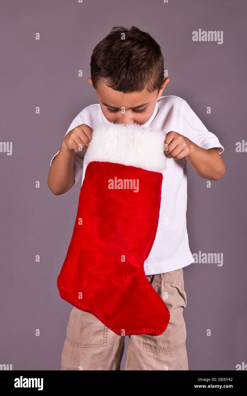 Little Boy guardare nella sua calza di Natale Foto Stock