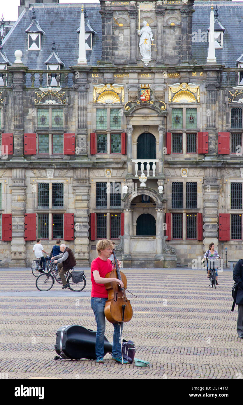 Il violoncellista musicista di strada in luogo di mercato (MARKT) e nel secolo XVII Municipio o Stadhuis in Delft, Paesi Bassi Foto Stock