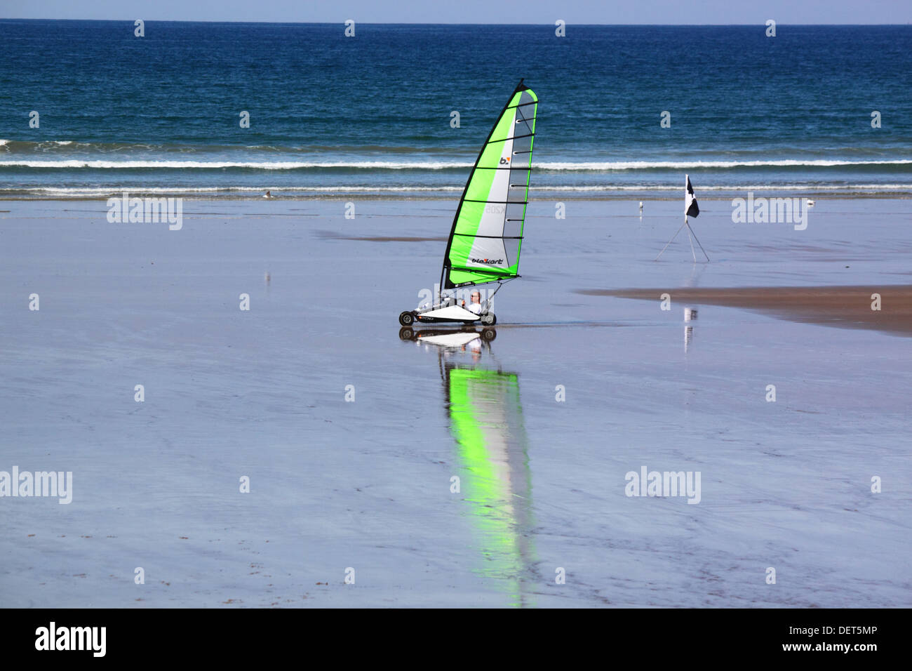 Una spiaggia di sabbia con yacht a vela verde sulle sabbie a Newgale, St Brides, Pembrokeshire. Foto Stock