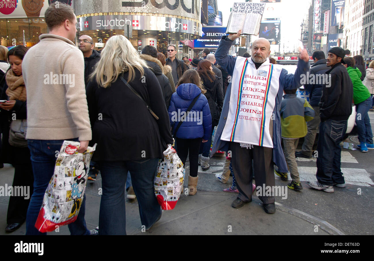 La folla degli acquirenti, per i turisti e un messaggero di Dio gravano le strade in ed intorno a Times Square a New York City. Foto Stock