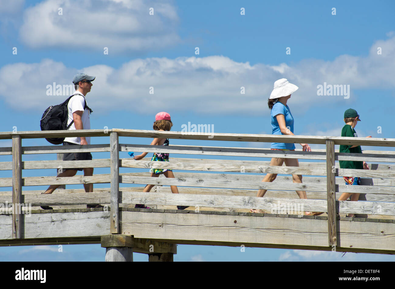 Famiglia sulla passerella in legno accesso spiaggia Foto Stock