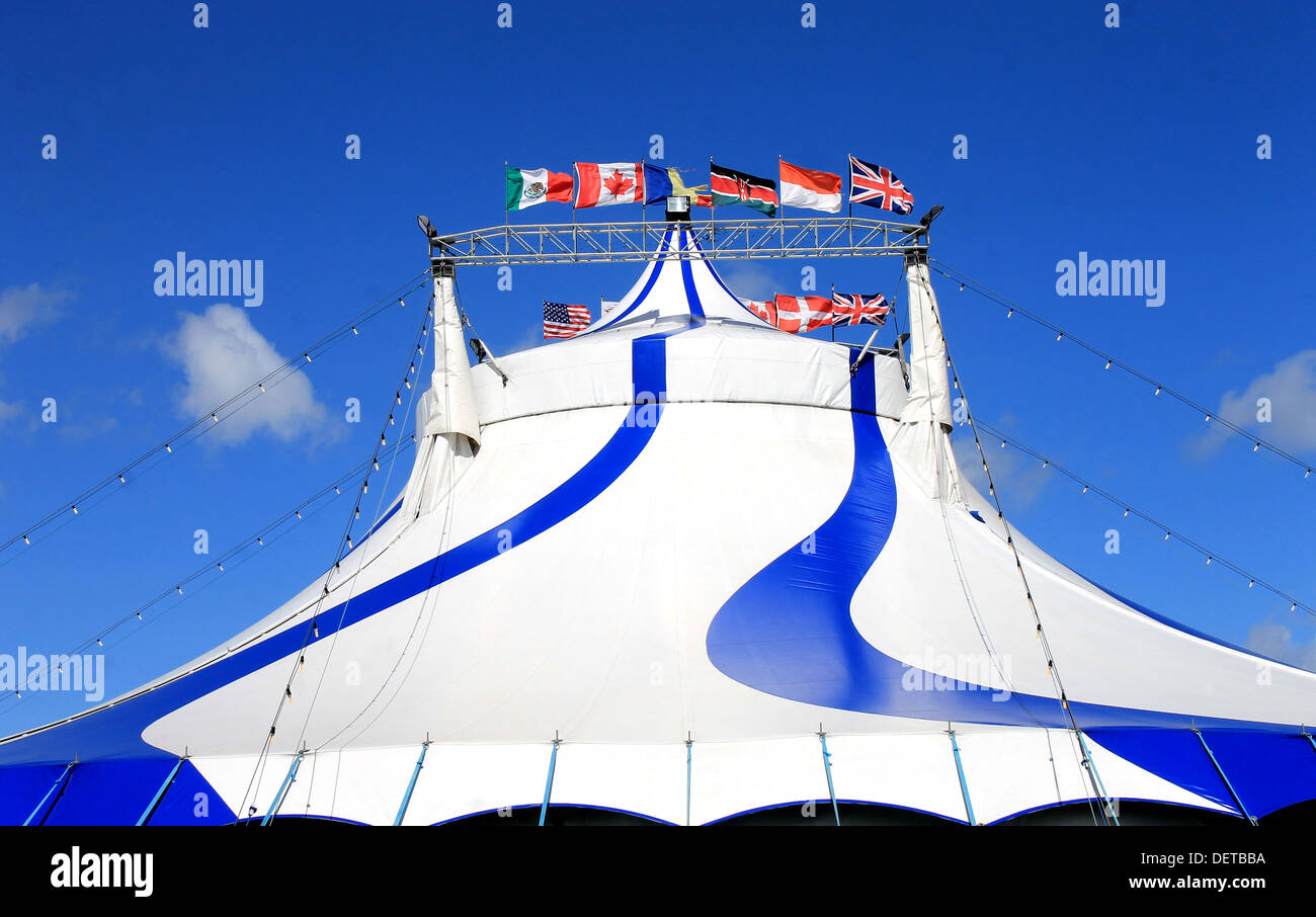 Esterno della tenda del circo con bandiere del mondo, cielo blu sullo sfondo. Foto Stock