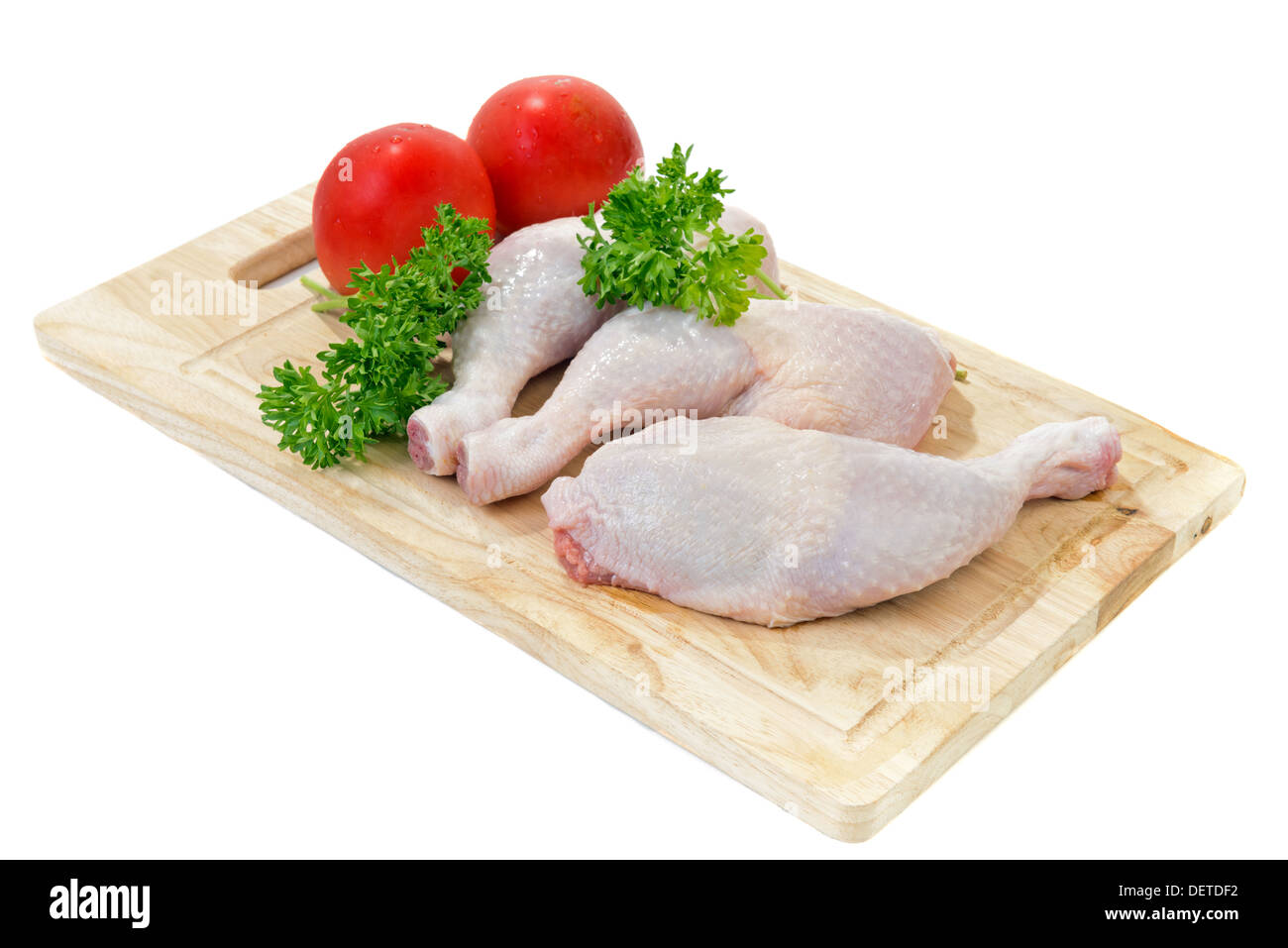 Materie le cosce di pollo con spezie e verdure sul tagliere Foto Stock