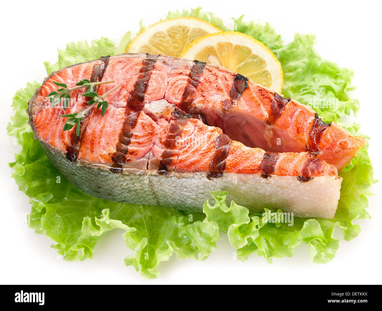 Salmone alla griglia e con le fette di limone overr foglie di lattuga. Immagine ravvicinata. Foto Stock