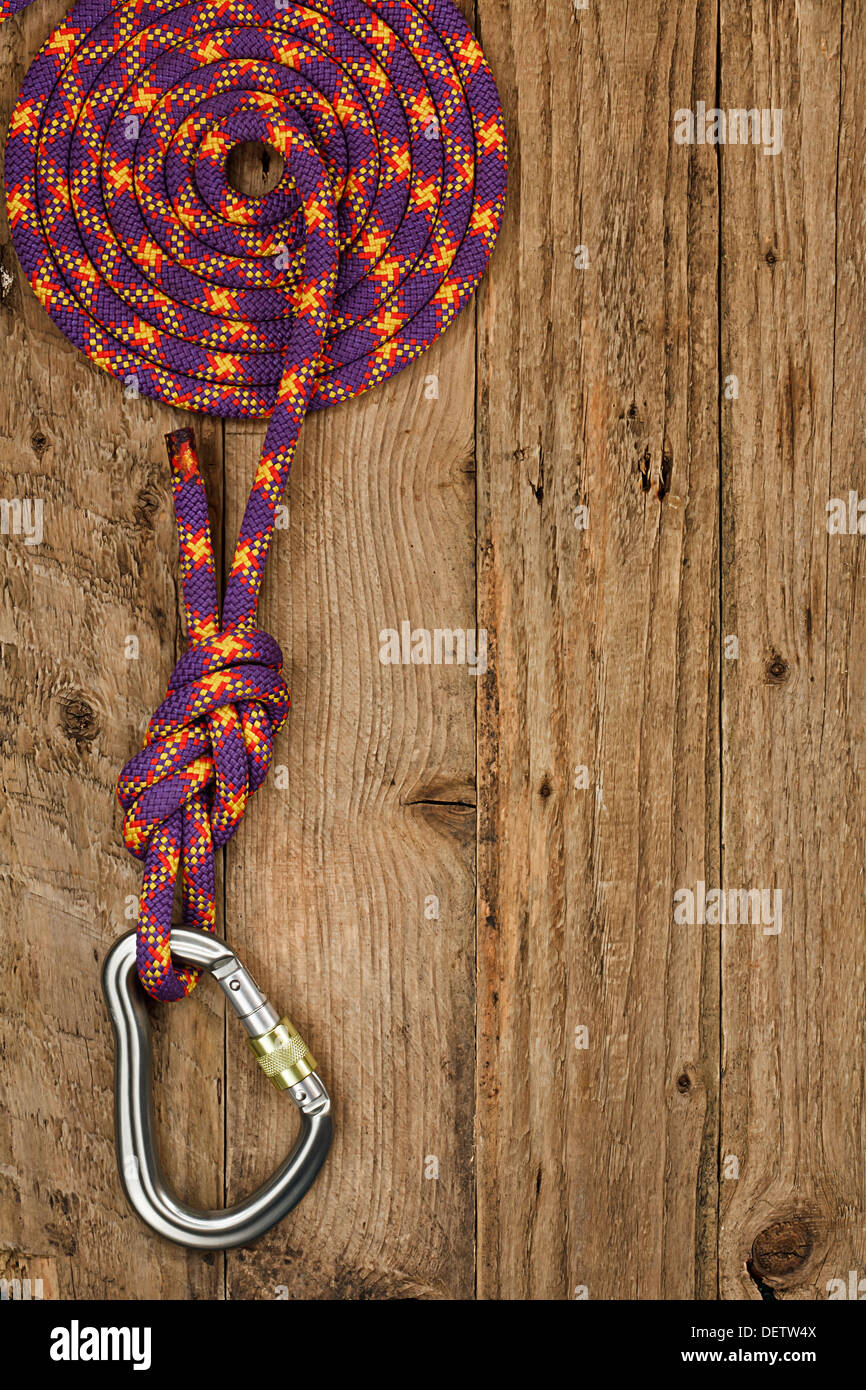 Arrampicata su roccia marcia con corda e il connettore sul rustico sfondo di legno spesso utilizzati per la sosta o la discesa in corda doppia dagli alpinisti Foto Stock