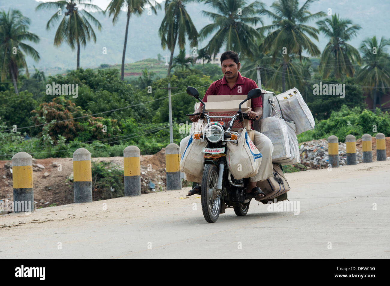 Indian uomo su scooter andare al mercato con la merce. Andhra Pradesh, India Foto Stock