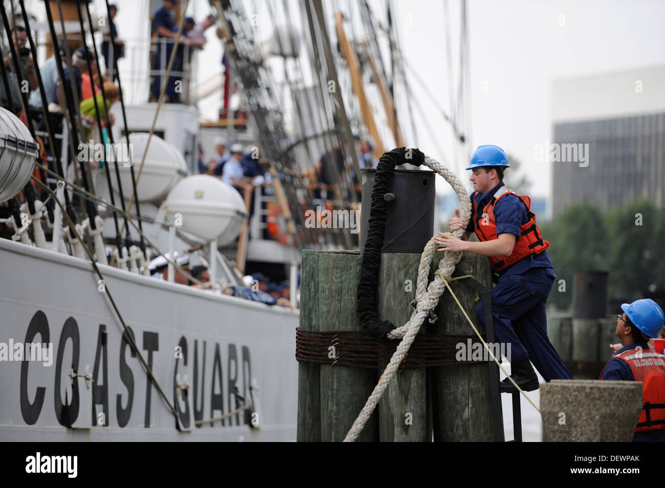 Un guardacoste degli Stati dal settore Hampton Roads aggancia una linea di ormeggio dai guardacoste Eagle intorno a un delfino alla High Street Lo sbarco nel centro di Portsmouth, Virginia, Venerdì, Settembre 13, 2013. L'Aquila, home-ported a New London, Connecticut, è un 295-fo Foto Stock
