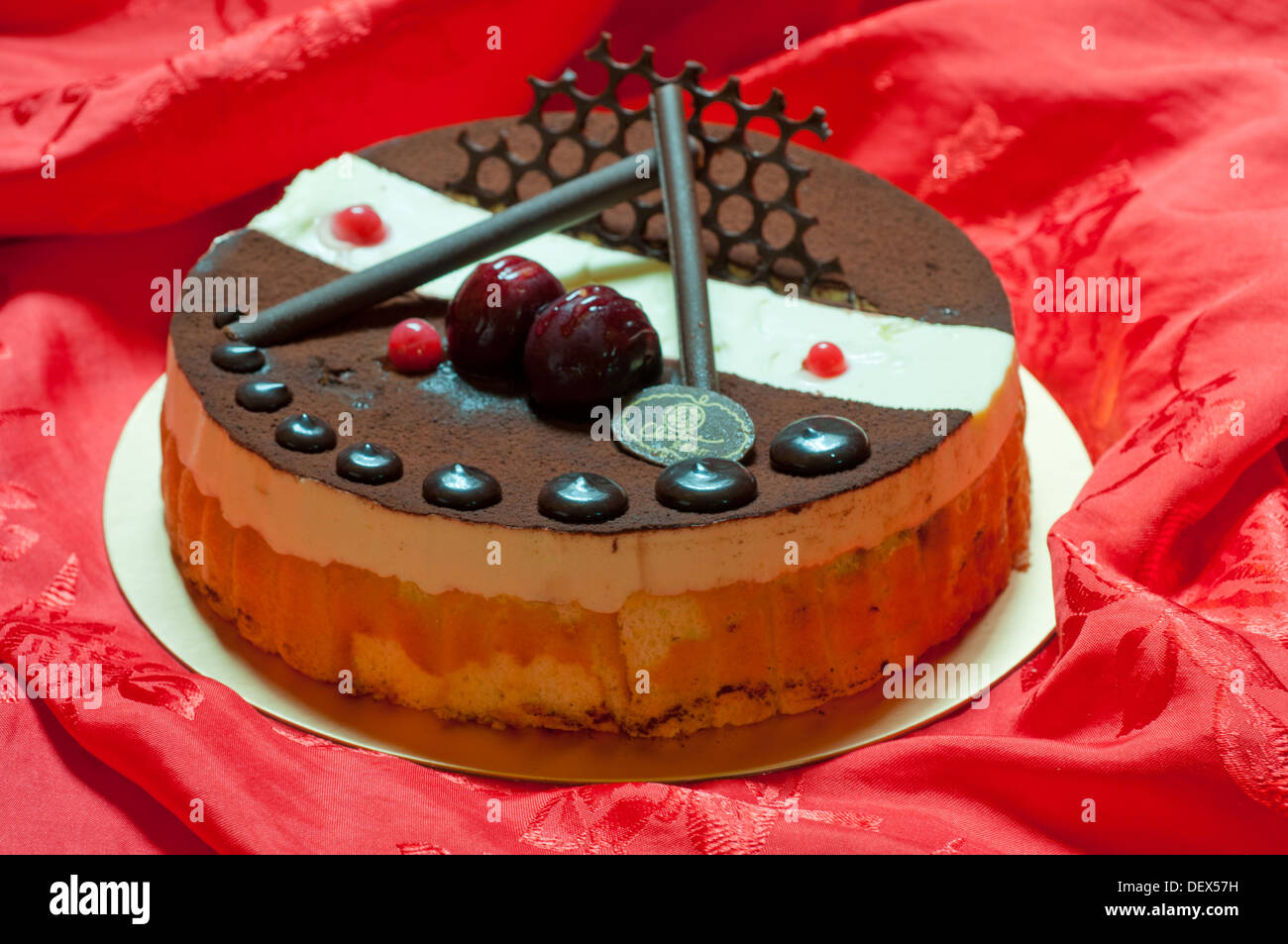 Cioccolato torta di compleanno su stoffa rossa sullo sfondo Foto Stock