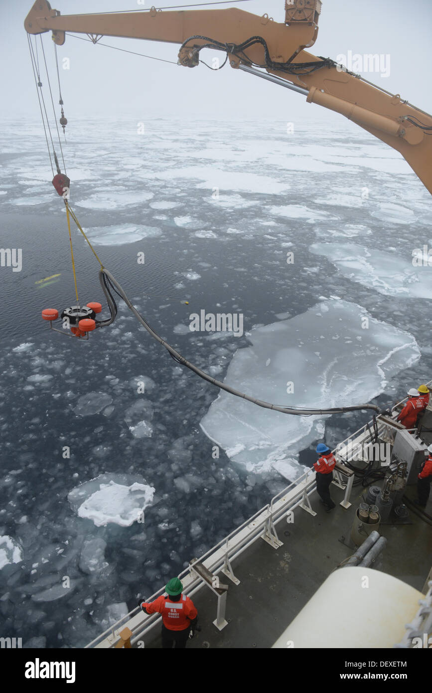 Membri del guardacoste Healy coperta inferiore di uno sfioratore dell'olio nel ghiaccio-laden Beaufort Sea durante la simulazione di una Foto Stock