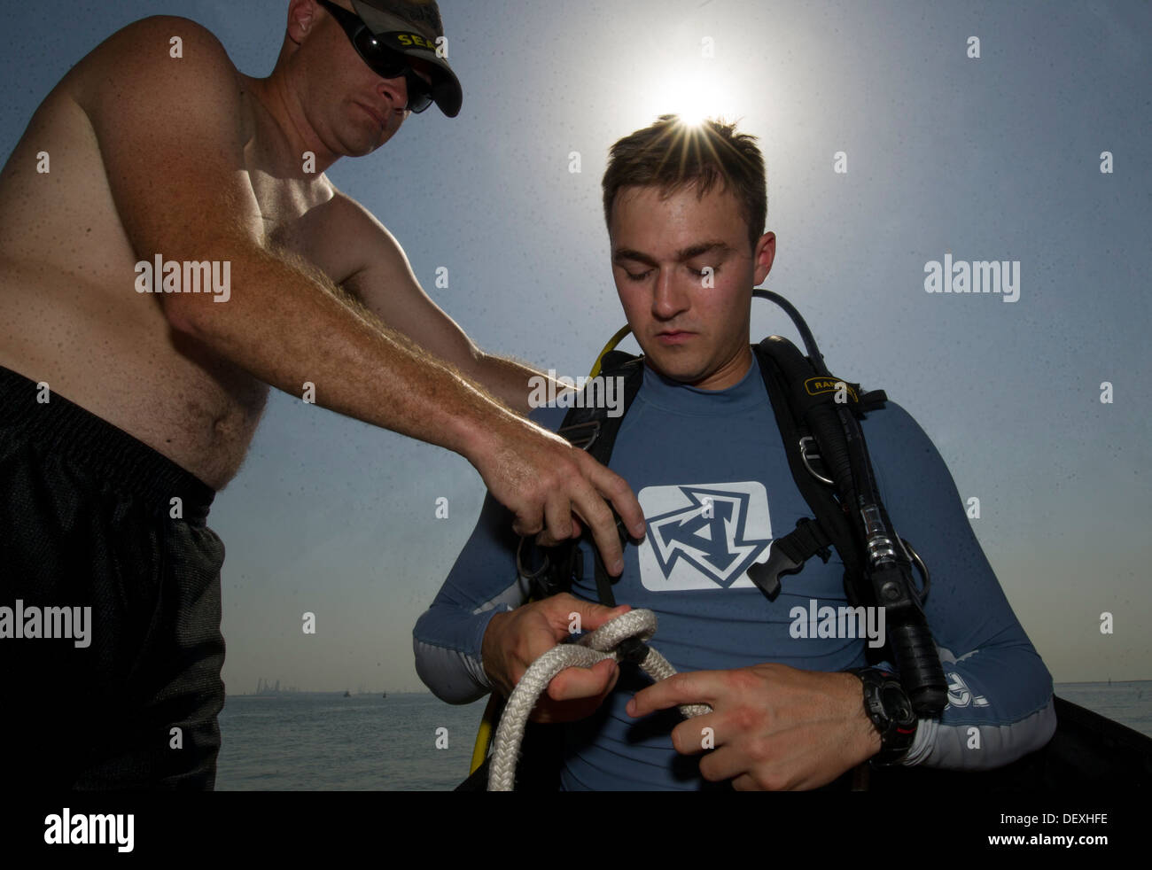 Costruzione meccanico 2a classe James Damon aiuta a Navy Diver 2a classe Trento Gobble, sia assegnato al comandante del gruppo di attività (CTG) 56.1, preparare la sua marcia per un anti-terrorismo forza il controllo di protezione. CTG 56.1 conduce le operazioni di sicurezza marittima e Foto Stock