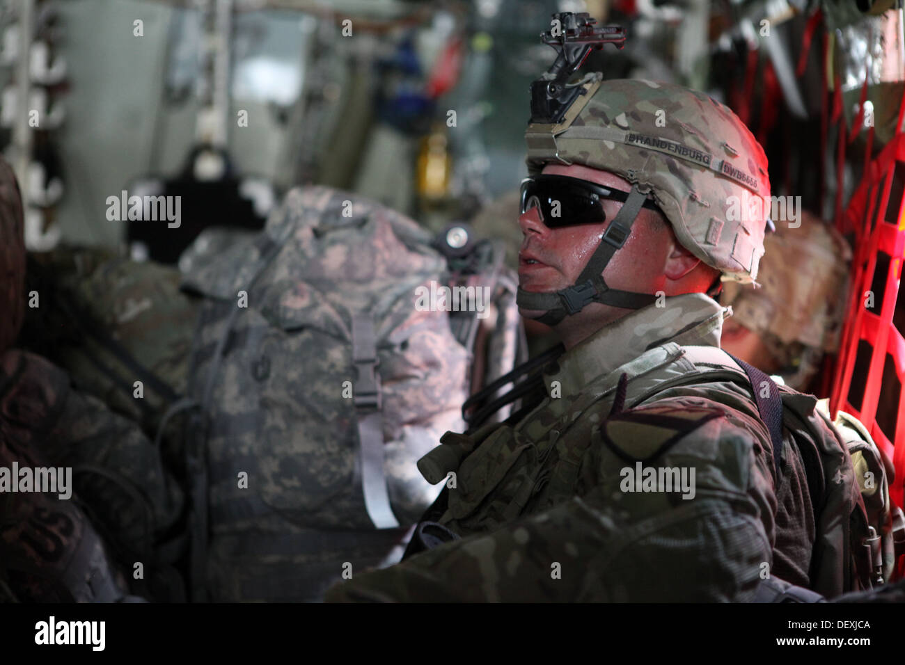 Stati Uniti Army Sgt. Bryan Brandenburg con Delta Company, 1° Battaglione, quinto reggimento di cavalleria, 2° Brigata Team di combattimento, 1° Divisione di cavalleria, si siede su un C - 130 a capo degli STATI UNITI Consolato nella provincia di Herat, Afghanistan, Sett. 14, 2013. Delta Company collabora Foto Stock