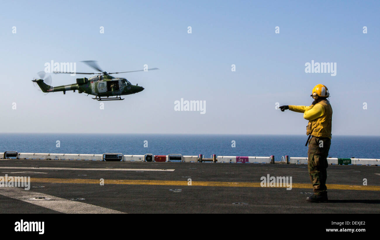 Un Westland Lynx battlefield elicottero assegnati al Regno Unito l'esercito del corpo aereo atterra sul ponte di volo della USS Kearsarge (LHD 3) durante la conduzione di qualifiche di sbarco, in mare, Sett. 15, 2013. Il ventiseiesimo MEU è un Marine Air-Ground Task Force forwar Foto Stock